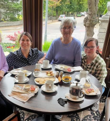 Residents enjoying afternoon tea at the Atholl Hotel, seated at a beautifully set table, smiling and sharing stories in a warm and welcoming atmosphere.