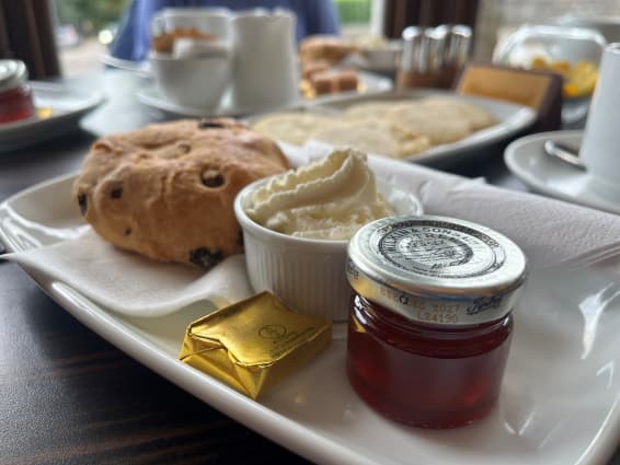 Residents enjoying afternoon tea at the Atholl Hotel, seated at a beautifully set table, smiling and sharing stories in a warm and welcoming atmosphere.