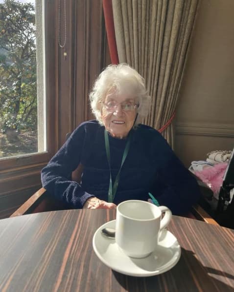 Residents enjoying afternoon tea at the Atholl Hotel, seated at a beautifully set table, smiling and sharing stories in a warm and welcoming atmosphere.