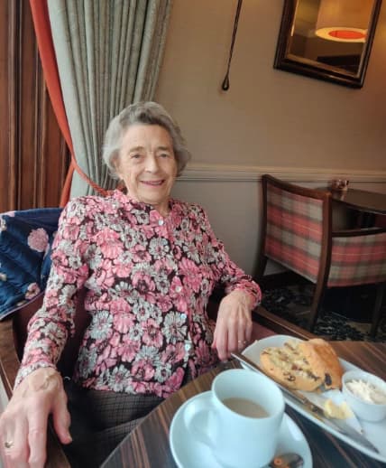 Residents enjoying afternoon tea at the Atholl Hotel, seated at a beautifully set table, smiling and sharing stories in a warm and welcoming atmosphere.