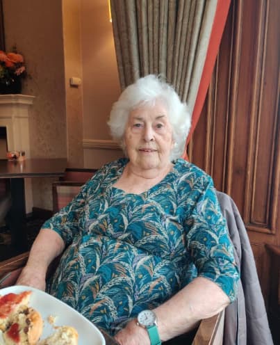 Residents enjoying afternoon tea at the Atholl Hotel, seated at a beautifully set table, smiling and sharing stories in a warm and welcoming atmosphere.